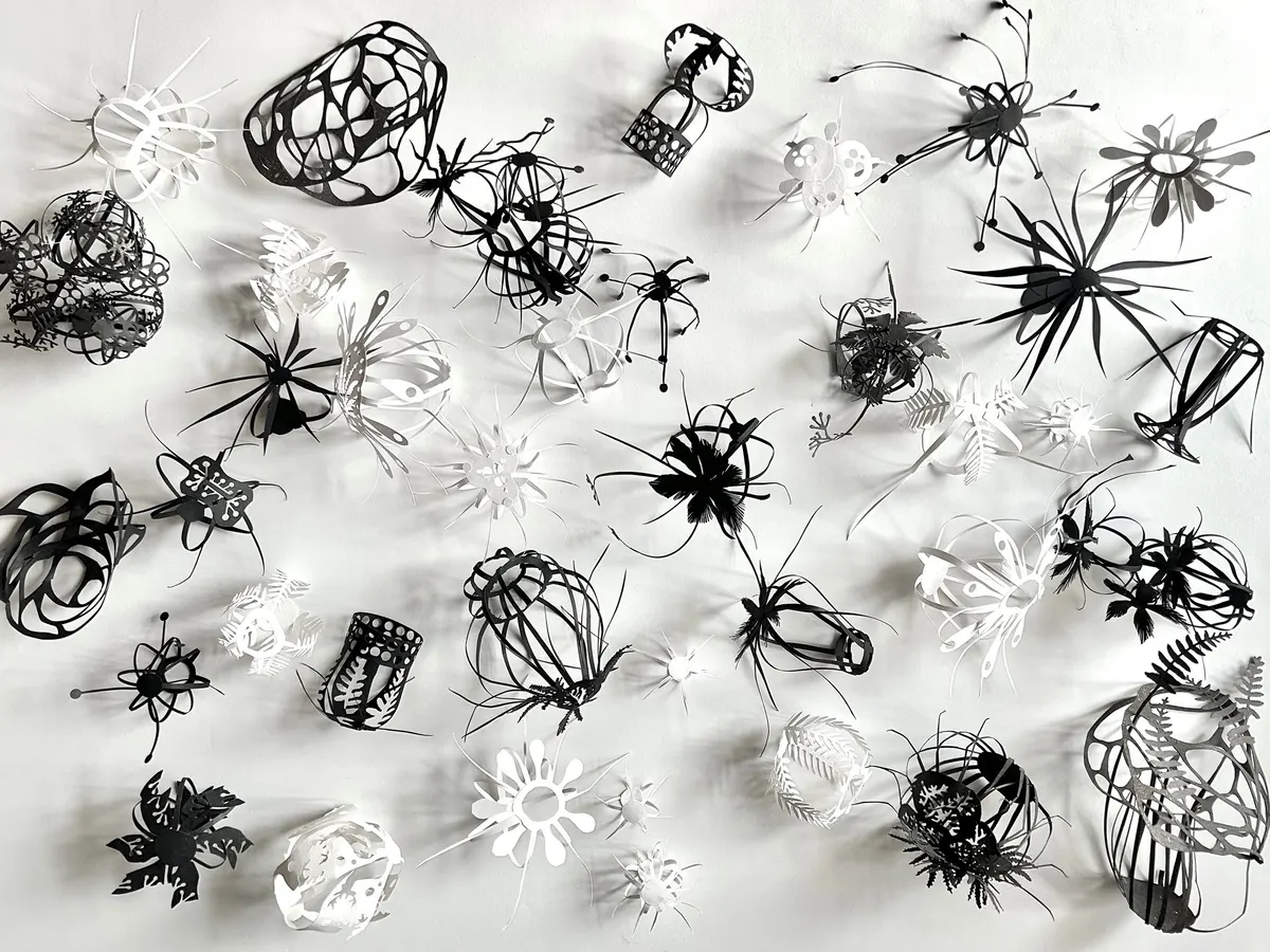 small black and white paper cut sculptures
