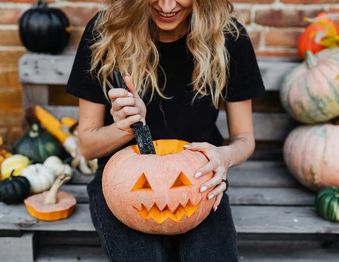 Woman Holding a Carved Pumpkin